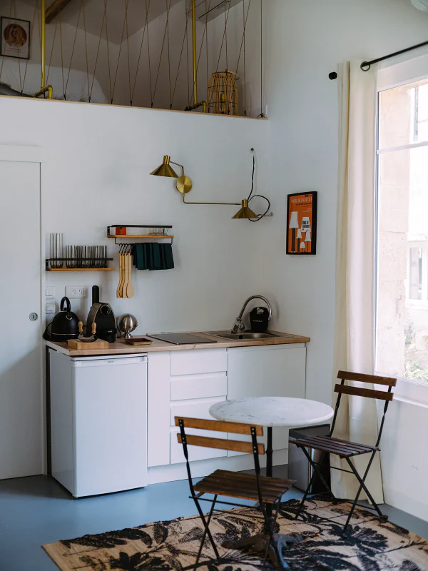 Kitchenette équipée avec mezzanine et table bistrot dans l'appartement du château