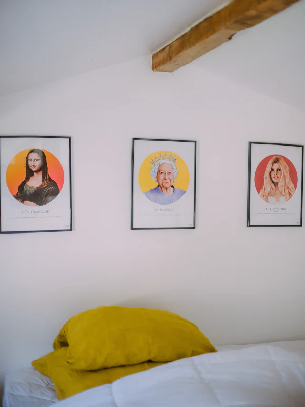 Mezzanine sous poutres avec affiches pop art et oreillers moutarde au château