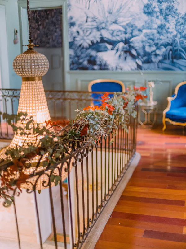 Palier du premier étage avec lustre, fresque bleue et fauteuils au Château de Laubardemont
