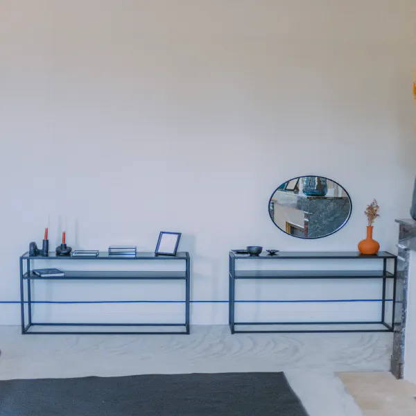 Consoles métalliques noires avec miroir rond et bougies dans la chambre du château