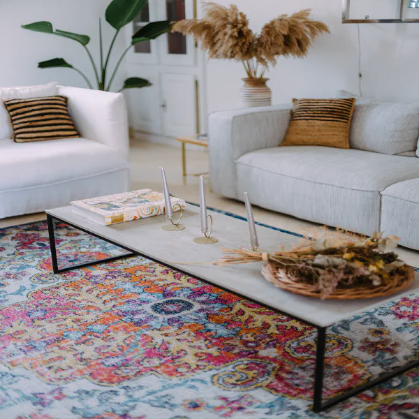 Salon cosy du Château de Laubardemont avec canapé lin, tapis coloré et fleurs séchées