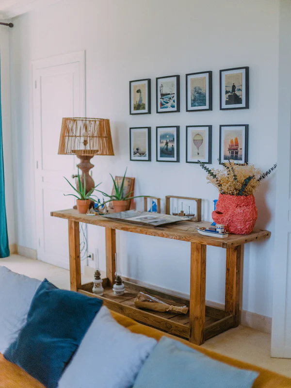 Console en bois avec galerie de cadres et plantes vertes dans le salon du château